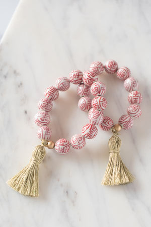 red and white chinoiserie beaded bracelet with gold tassel