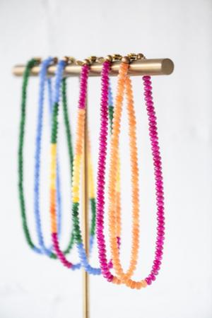hanging glass beaded necklaces of multi color variations on display