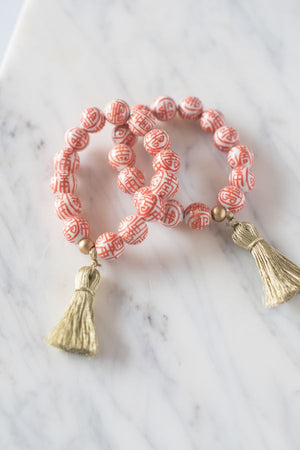 orange and white chinoiserie beaded bracelet with gold tassel