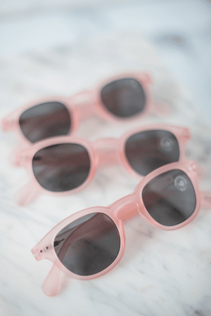 Pink transparent sunglasses with blurred marble background